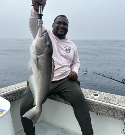 African American man holding a large fish he caught with Chasin' Tides Charters